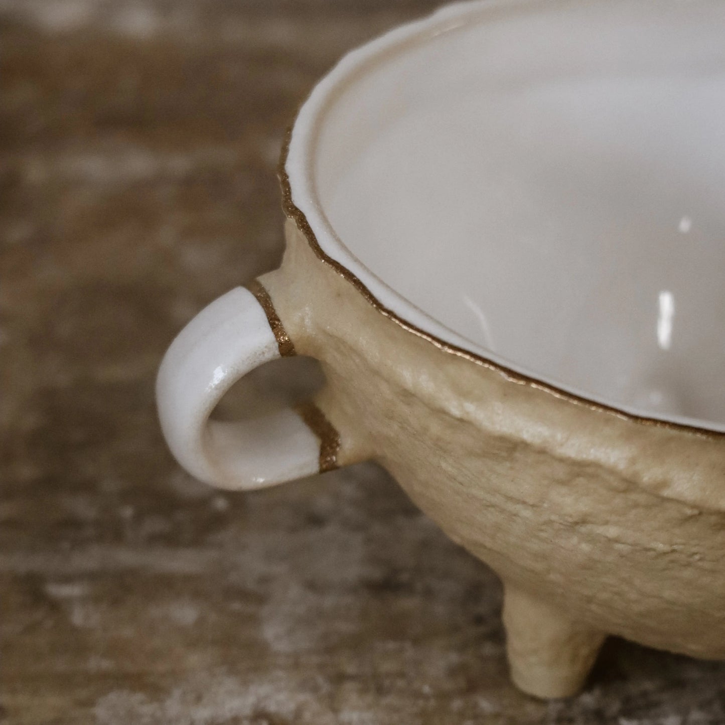 Close-up of handle detail and gold-edged rim of Nosse Ubuntu Bowl