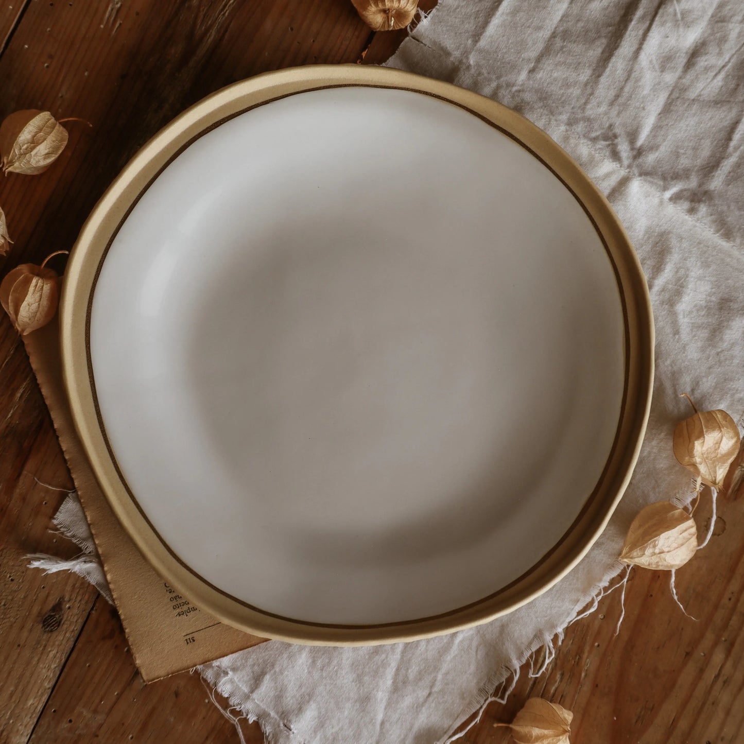 Top view of Nosse Ubuntu Plate Aura Gold on linen and wood background