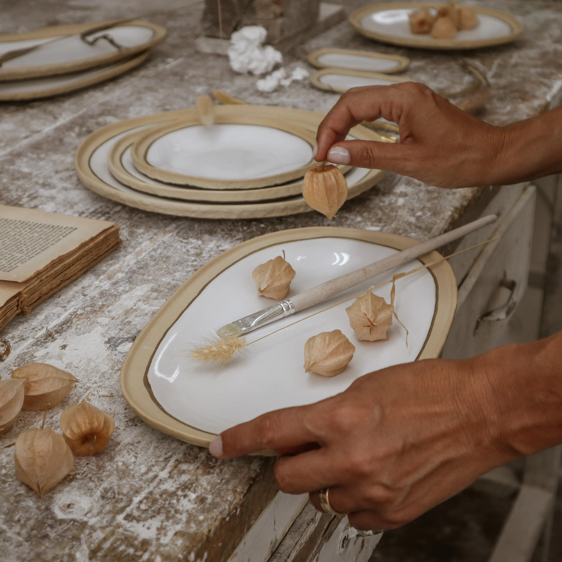 Nosse modern ceramics collection on rustic table with beige and white platters, Portuguese tableware.